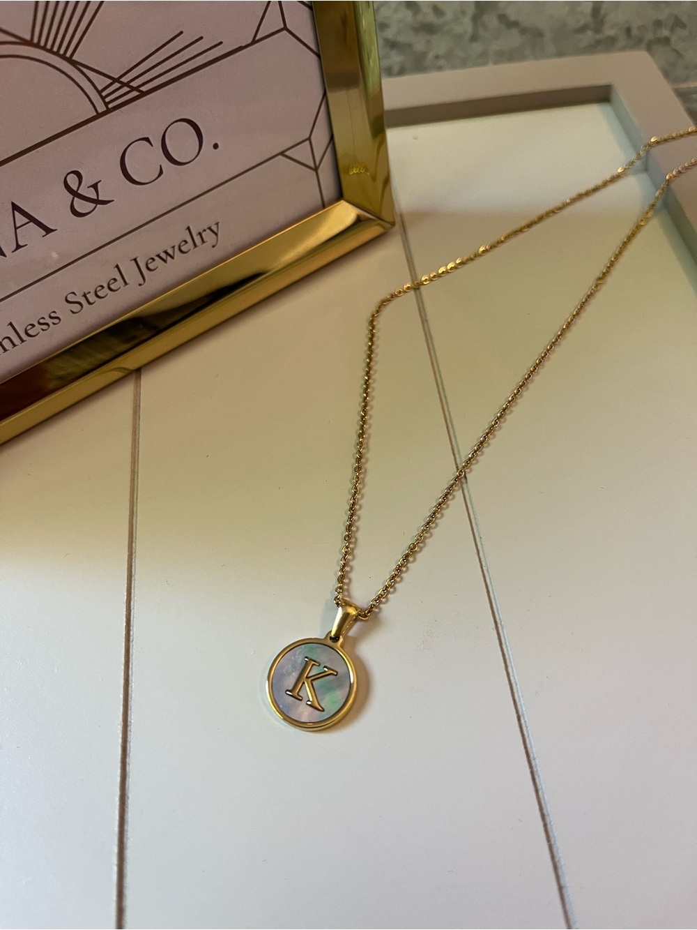 Stainless Steel Gold Initial Necklace Letter “K” with a blue/purple inlay.
